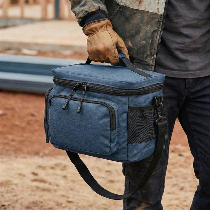 Super Duty 12 - Lunch Cooler - A blue lunch cooler bag with a handle and shoulder strap, featuring pockets and zippers, held by a gloved hand.