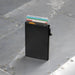 Wally Mag RFID Case - A black RFID case holding multiple cards, set against a metallic surface. The case features a clip on the side.