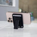 Wally Stand - A phone with a black wallet case and kickstand, resting on a marble surface, featuring visible credit cards.