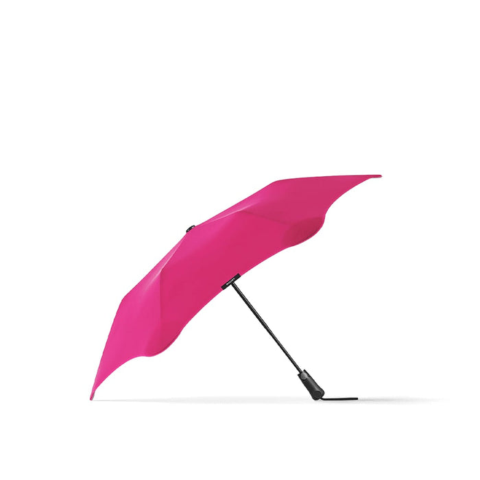 BLUNT Metro Umbrella - A bright pink BLUNT Metro Umbrella with a sleek black handle and a unique design.