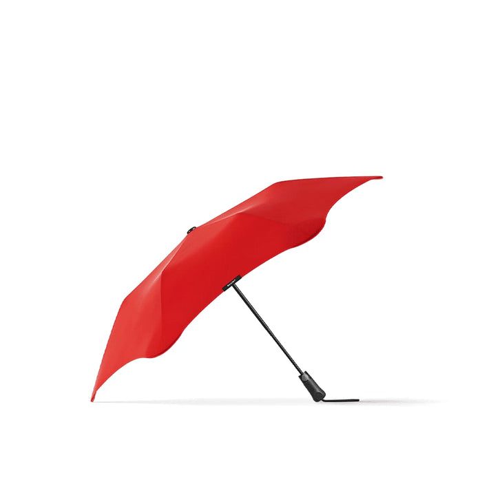 BLUNT Metro Umbrella - A red BLUNT Metro Umbrella with a sleek design and a black handle, featuring a logo.