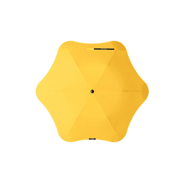 BLUNT Metro Umbrella - A yellow BLUNT Metro Umbrella with a distinctive design and a central button. It features a logo.