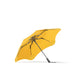BLUNT Metro Umbrella - A yellow BLUNT Metro Umbrella with a black frame, featuring a unique, stylish design and a logo.