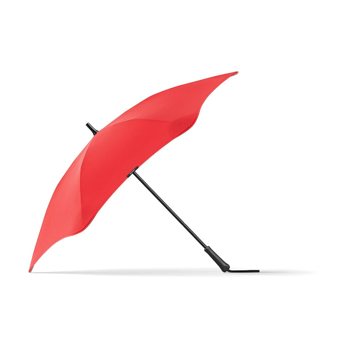 BLUNT Classic Umbrella - A red BLUNT Classic Umbrella with a black handle, showcasing its unique curved design. It features a logo on the canopy.