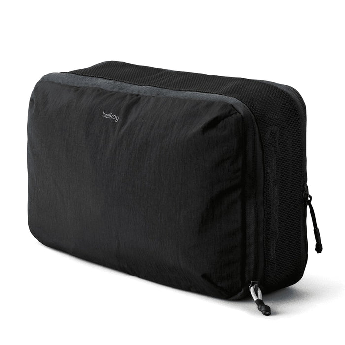 Bellroy Lite Packing Cube 12L - A black packing cube with a mesh panel, featuring a logo and a zipper closure.