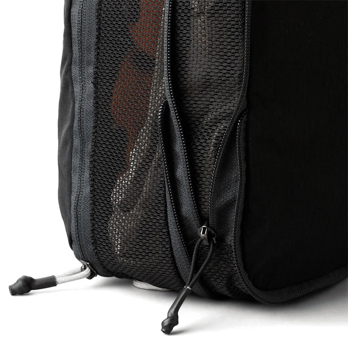 Bellroy Lite Packing Cube 12L - A black packing cube with a mesh side and a zippered opening, showcasing its compact design.