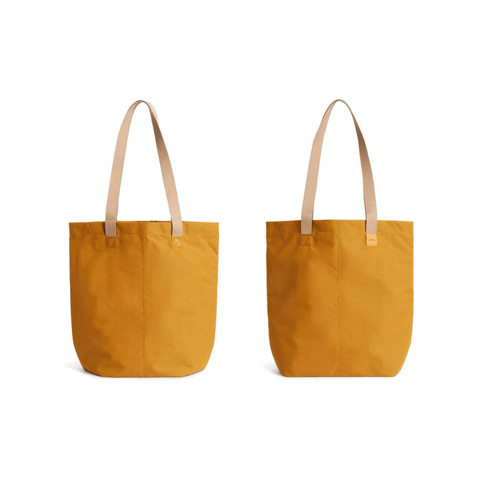 Bellroy City Tote - A yellow tote bag with tan straps, featuring a logo. Two angles displayed.