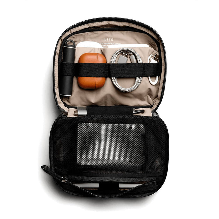 Bellroy Lite Tech Kit - A black tech kit opened to reveal a drink bottle, orange case, cords, and a mesh pocket.