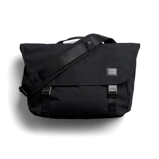 Bellroy Classic Messenger 13L - A black messenger bag with a flap, adjustable shoulder strap, and branding label. It features buckle closures and a sleek design.
