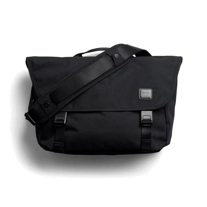 Bellroy Classic Messenger 13L - A black messenger bag with a flap, adjustable shoulder strap, and branding label. It features buckle closures and a sleek design.