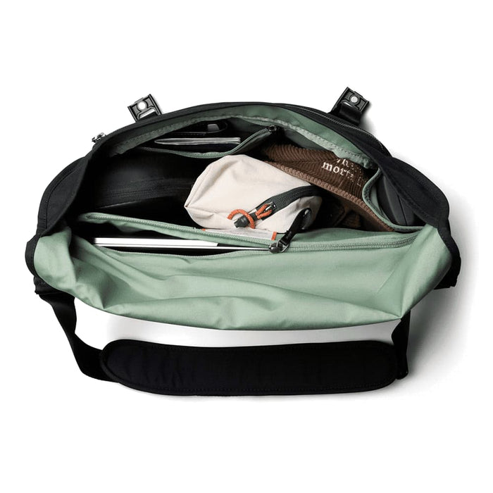 Bellroy Classic Messenger 13L - A black and mint green messenger bag opened to reveal multiple compartments, including a laptop sleeve and pouches.