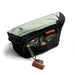 Bellroy Classic Messenger 13L - A black messenger bag with a green interior and multiple compartments, holding devices and accessories.