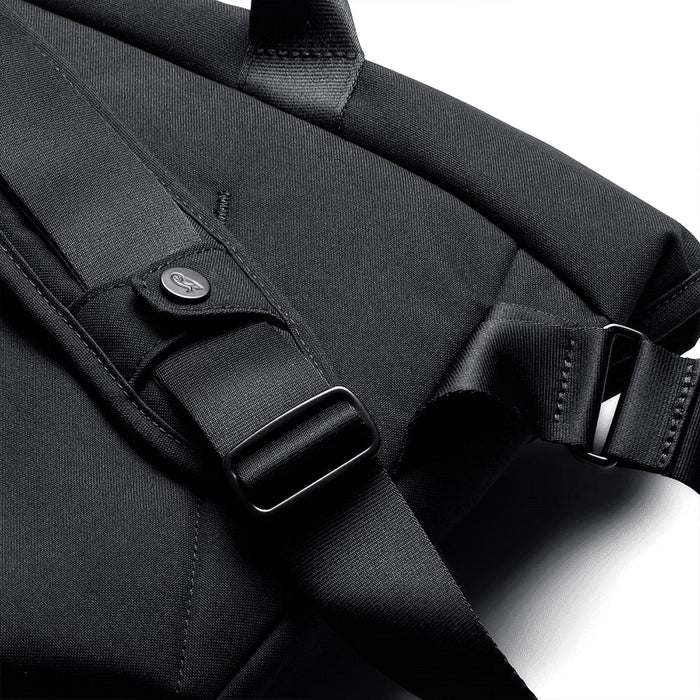 Bellroy Classic Messenger 13L - A black messenger bag featuring adjustable straps and a logo. The material appears textured and durable.