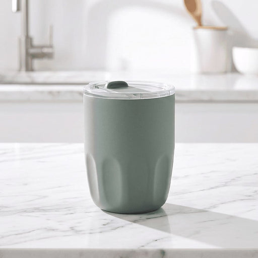 Carry Cup Olla Vacuum Coffee Cup w/ Ceramic Liner - 300ml - A drink bottle in a soft green hue with a clear lid, featuring a textured body and an internal ceramic liner.