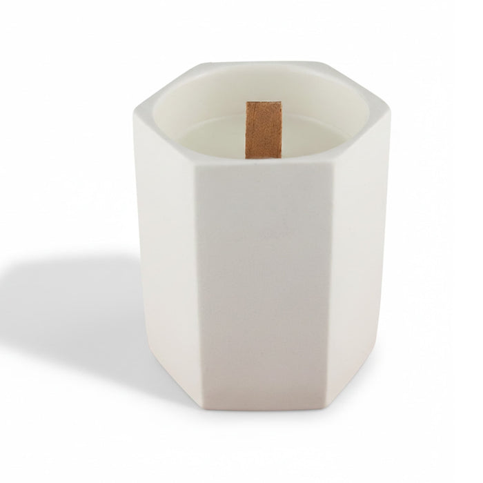 Noosa Hexagon Ceramic Candle - A white hexagonal ceramic candle with a wooden wick placed inside. It has a minimalist design.