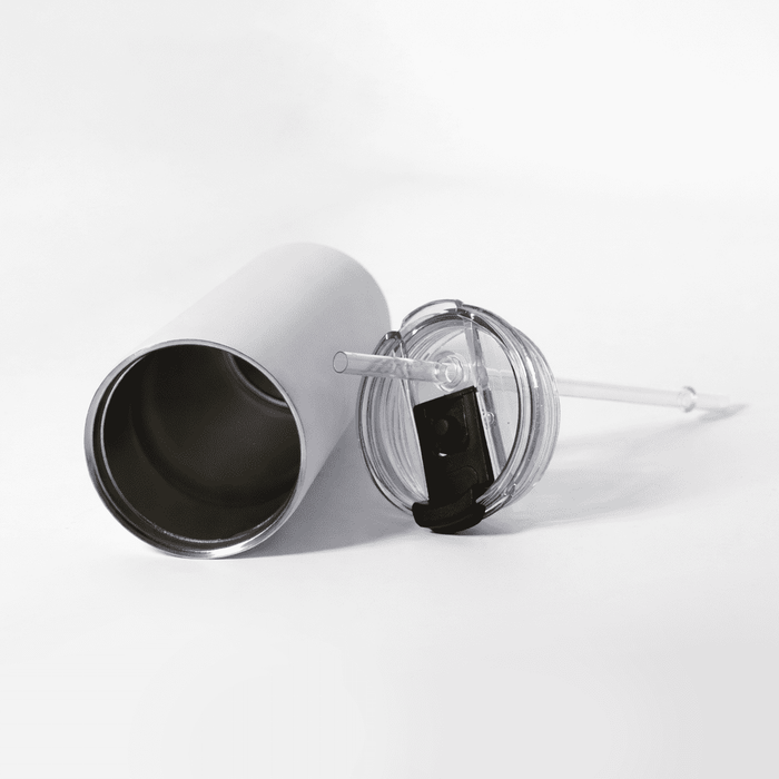 The Connor 600ml Vacuum Tumbler - A drink bottle with a silver exterior, a clear lid, and a reusable straw lies on a white surface.