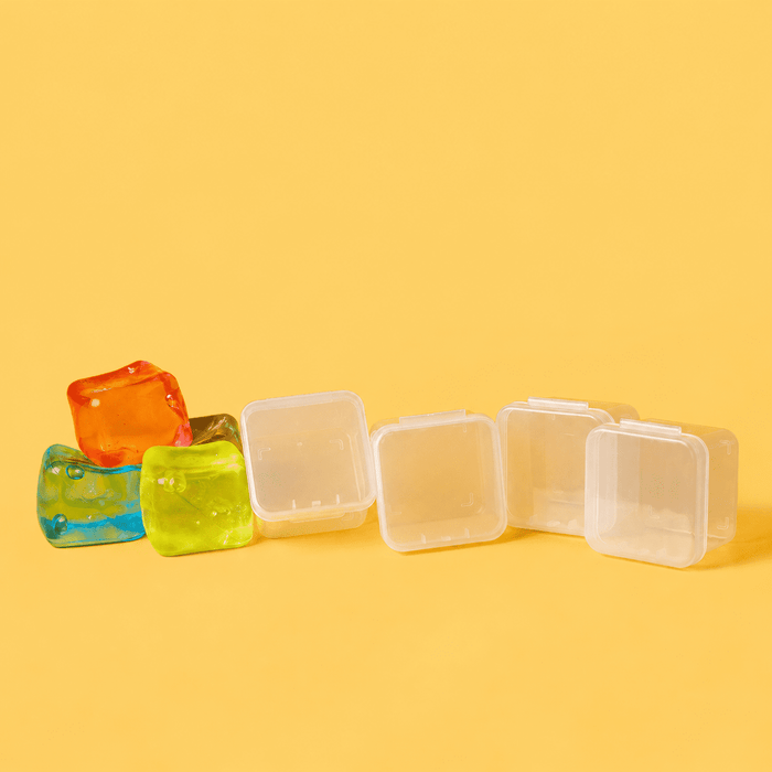 Jelly Cube Sensory Toy - A row of clear plastic jelly cube sensory toys in orange, blue, and green against a yellow background.