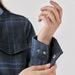 Women's Highland Sherpa Lined Plaid Jacket - A close-up of a women's plaid jacket featuring a dark blue pattern and visible snap buttons on the cuffs.