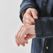 Women's Highland Sherpa Lined Plaid Jacket - A plaid jacket in a dark blue hue, featuring a Sherpa lining and buttoned cuffs, is being showcased with hands adjusting the sleeve.
