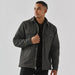 Men's Oxide Sherpa Lined Canvas Jacket - A men's dark grey Sherpa lined canvas jacket with front pockets and a collared neckline. It has a subtle logo.
