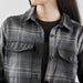 Women's Highland Plaid Shacket - A stylish women's shacket featuring a black and grey Highland plaid pattern with buttoned pockets.