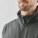 Men's Athabasca Thermal Jacket - A grey thermal jacket featuring a high collar and zip closure, modelled by a man with a beard.