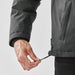 Men's Athabasca Thermal Jacket - A hand adjusting the hem of a men's thermal jacket in a dark colour, featuring a logo on its side.