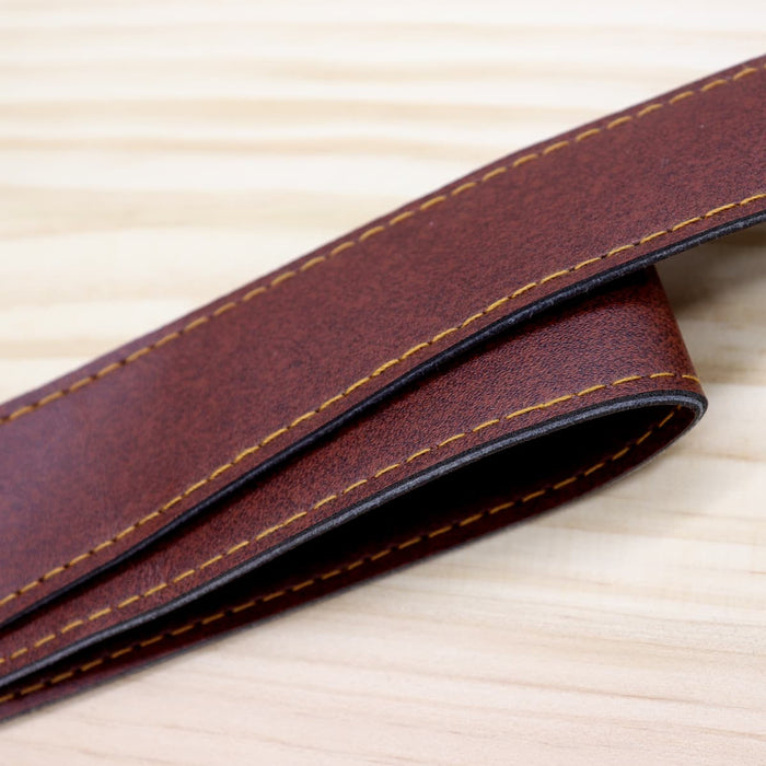 Saint-Rémy Cooler Basket - A brown faux leather strap with contrasting yellow stitching, laid flat on a wooden surface.
