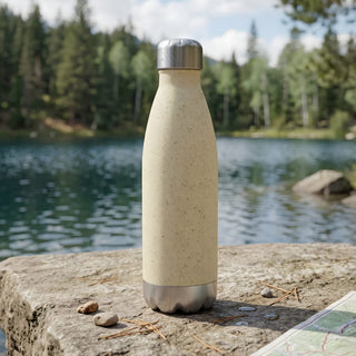 Komo Wheat Straw Drink Bottle - A drink bottle in a light beige colour with a stainless steel base, set against a scenic lakeside background.