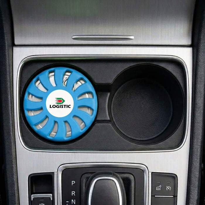 Air Freshener – Ocean - A blue air freshener with a circular design, placed in a car's cup holder. It has a logo on it.