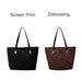 Suede Leather Tote Bag - A black tote bag with a shiny finish and a brown suede leather tote bag, both featuring a logo.