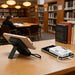 10000mAh Magnetic Wireless  Power Bank with Charging Cable - A wireless power bank with a charging cable, featuring a sleek design and a stand, placed on a library table.