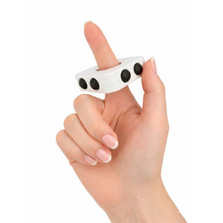 Decompression Finger Spinner - A white finger spinner held between fingers, featuring three black buttons on its surface.