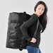 Stormtech Gear Bag Medium - A medium black duffle bag featured being carried by a person, with adjustable straps and buckles visible.
