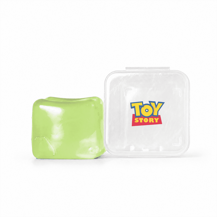 Jelly Cube Sensory Toy - A green jelly cube sensory toy next to a clear container featuring a logo.