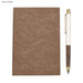 Falby Notebook and Pen Gift Set - A brown notebook with a textured cover and a white pen with a wooden design, featuring a logo.