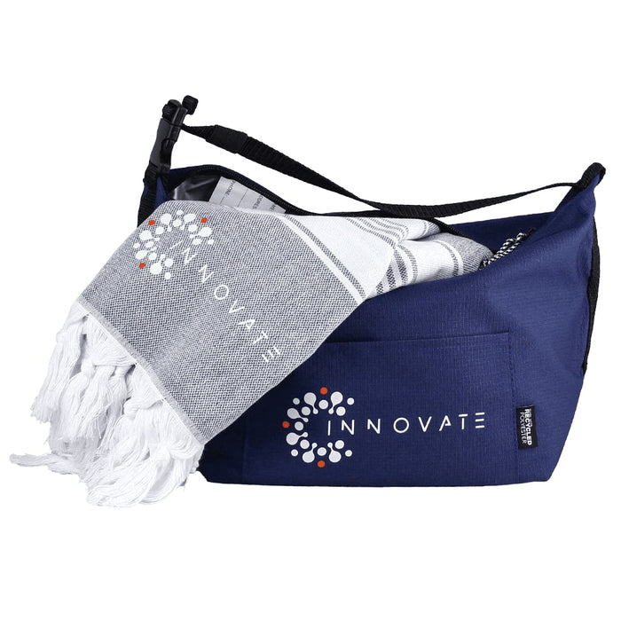 Towel & Cooler Bundle Pack - A navy cooler bag with a white and grey towel peeking out, featuring a logo on both items.