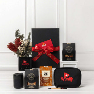 Branded Tech Kit Gift Pack - A black gift box tied with a red ribbon contains various items, including a drink bottle, a coffee pack, and a branded pouch.