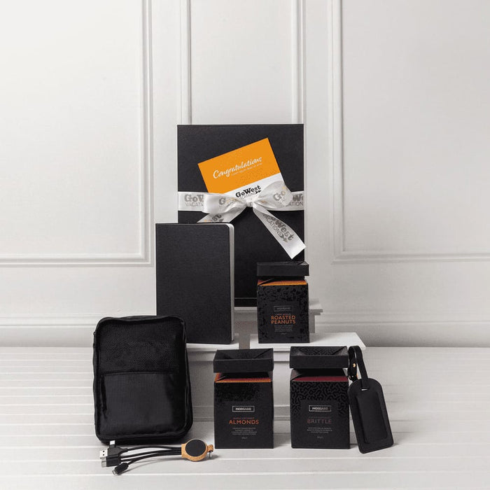 The Custom Travel Kit - A travel kit featuring a notebook, two black boxes, a pouch, and a tag. All items are arranged on a white surface.