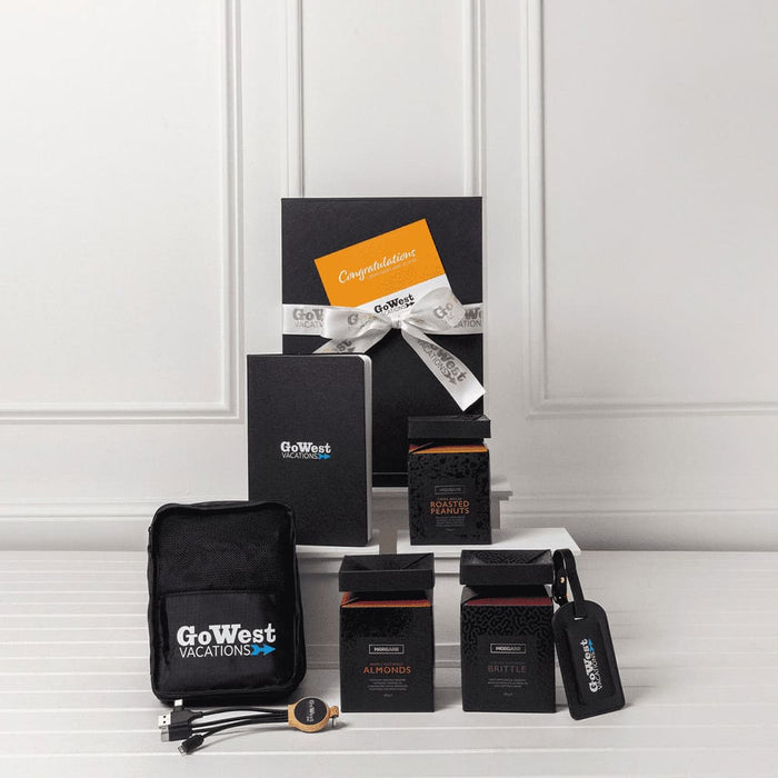 The Custom Travel Kit - A travel kit featuring a black pouch, travel accessories, two boxes, and a notebook, all packaged in a stylish setup.