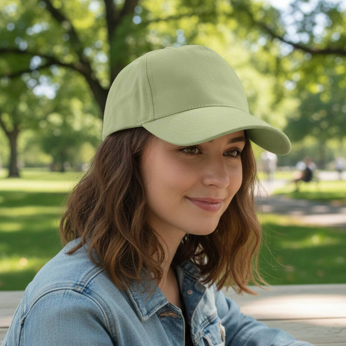 Flexi Cap - A drink bottle in light green with a curved peak, featuring a logo on the front. Surrounded by greenery.