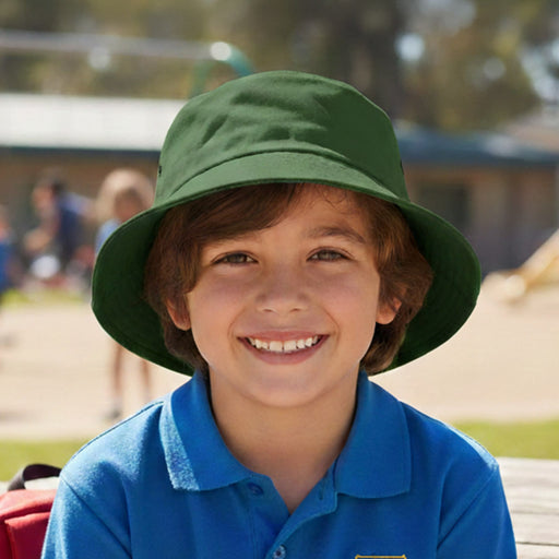 Long Beach Bucket Hat – Small - A green bucket hat on a smiling child, with a playground scene in the background. The hat has a logo.