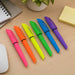 Gear Pen Highlighter - A set of six highlighter pens in bright pink, orange, yellow, green, blue, and purple, placed on a desk with stationery.