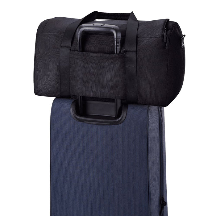 High Sierra Camille Duffel 31L - A black duffel bag rests on top of a dark blue suitcase, featuring straps and a handle.