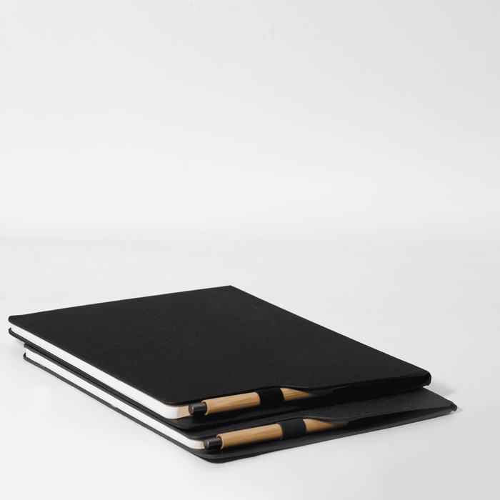 SunScribe Notebook (A4) - A black A4 notebook stacked with a pen, featuring a simple design and a logo on the cover.
