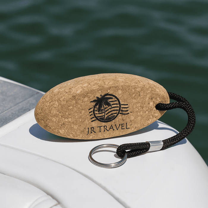 Cork Floating Keychain - A cork keychain in an oval shape with a black rope and a keyring, featuring a logo with a palm tree.