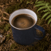 The Murray 500ml Mug - A drink bottle featuring a navy blue mug filled with dark coffee, set on a natural, forested background.