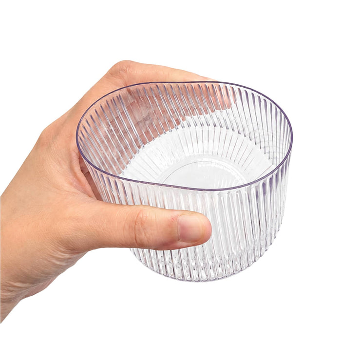 Velora Tumbler by The Line Edit. - A clear, ribbed tumbler held in a hand, featuring a stylish design and a transparent appearance.