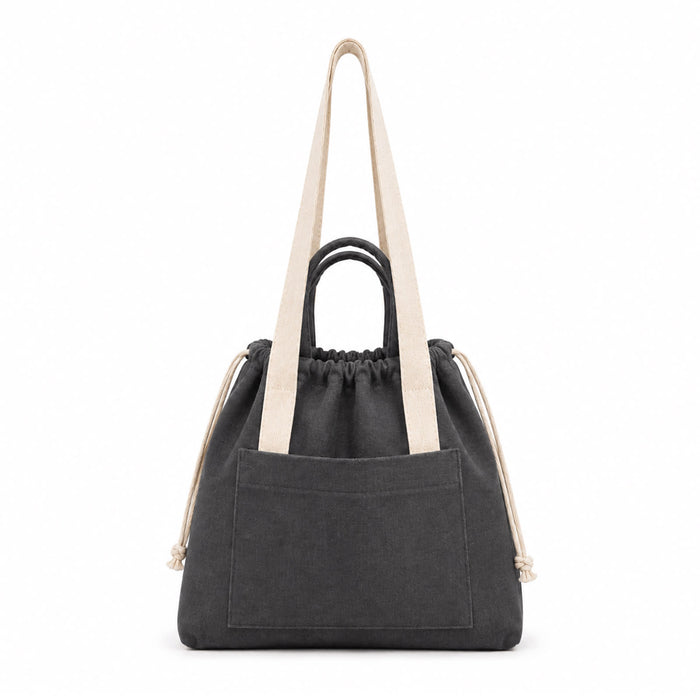 Darby Tote Bag - A grey tote bag with long fabric straps, featuring a drawstring closure and a front pocket. It has a simple branding detail.