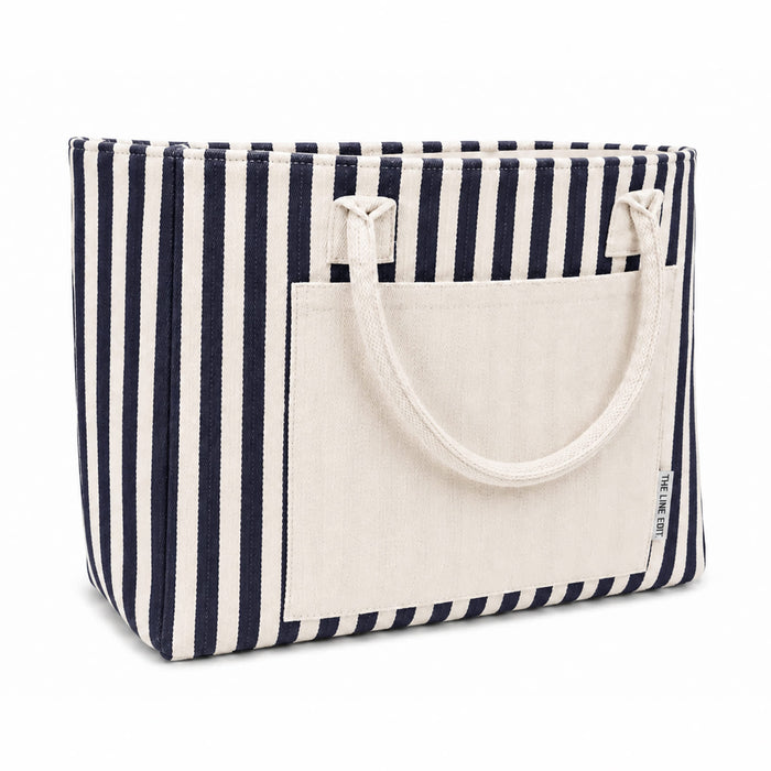 Hampton Tote Bag by The Line Edit. - A striped tote bag featuring navy and white stripes with a solid cream front pocket and two handles.